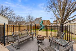 un patio con 2 sillas, una mesa y un parque infantil en Family Friendly Home in South Austin, en Austin