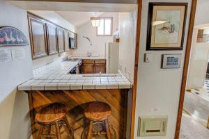 una cocina con una encimera con dos taburetes. en Aspen Creek #401 Year-Round Outdoor Activities, en Mammoth Lakes