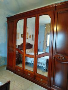 a wooden cabinet with glass doors in a bedroom at MarGaMik Holiday in Aradeo