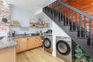 a kitchen with a washer and dryer under a staircase at Urban Loft - City Center Walk to Everything in Saint Augustine +27 photos