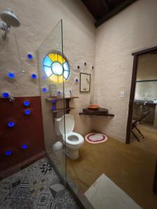 ein Badezimmer mit Toilette und Buntglasfenster in der Unterkunft Ecocentro Brasil - Bangalô 3 in São Pedro