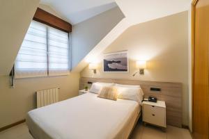 a bedroom with a large white bed and a window at Miracielos in Barro de Llanes