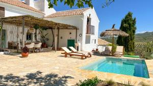 a backyard with a swimming pool and a house at Cortijo La Pedriza in Iznájar