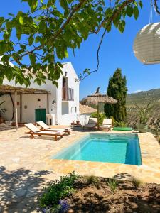 una villa con piscina e una casa di Cortijo La Pedriza a Iznájar