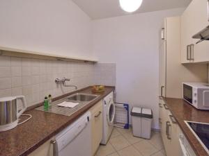 a kitchen with a sink and a microwave at Holiday apartment by the swimming pool F 997 in Fehmarn
