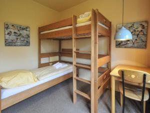 a bedroom with bunk beds and a table and a desk at Holiday apartment by the swimming pool F 997 in Fehmarn