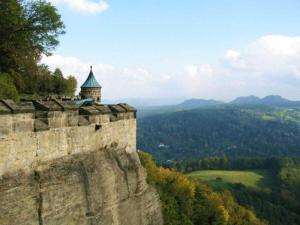 a stone wall with a tower on top of a mountain at above painters studio in Pirna