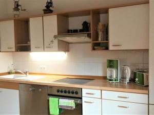 a kitchen with white cabinets and a stove top oven at above painters studio in Pirna