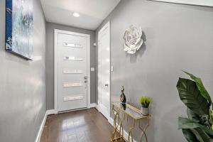 a hallway with a white door and a plant at Luxury Downtown Home with Rooftop Deck And Skyline View in Angleton +21 photos