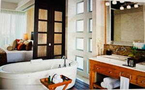 a bathroom with a tub and a bedroom with a bed at Vidanta Grand Legacy Resort in Jarretadera