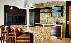 a kitchen with a granite counter top and wooden cabinets at Vidanta Grand Legacy Resort in Jarretadera