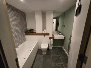 een badkamer met een bad, een toilet en een wastafel bij Ventro Apartments LIVERPOOL in Liverpool +28 foto's
