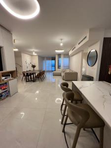 a kitchen and living room with a table and chairs at פנטאהוז מרהיב ויוקרתי 6 חדרים ! יש ממד בתוך הבית ! in Beit Shemesh