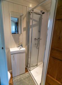 a bathroom with a shower and a sink at Lavender Retreat with Private Hot Tub in Upper Hulme