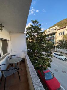 a balcony with a whiteboard and a red car on a street at Centerside Apartment in Ulcinj