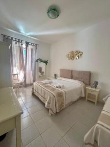 a bedroom with a large bed with a fan at Affittacamere Il Magnon in Santa Teresa Gallura +21 photos