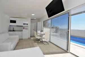 a living room with a couch and a kitchen and a large window at House Luxury in Matulji