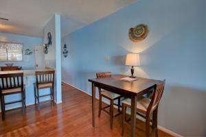 a dining room with a table and chairs and a kitchen at Topsail Dunes 2308 in Chadwick Acres