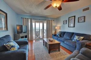 a living room with blue couches and a tv at Topsail Dunes 2308 in Chadwick Acres