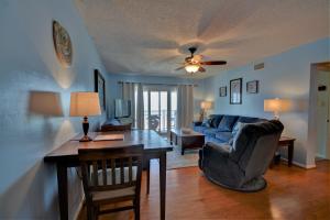 a living room with a table and a couch at Topsail Dunes 2308 in Chadwick Acres +18 photos