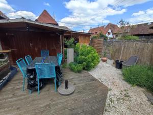 a patio with a table and chairs on a wooden deck at Charmante maison alsacienne, sauna et jardin in Châtenois