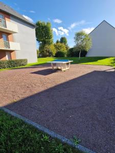 un tavolo da picnic di fronte a un edificio di Superbe appartement en residence avec piscine a La Rivière Saint Sauveur