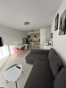 un soggiorno con un divano e un tavolo di Superbe appartement en residence avec piscine a La Rivière Saint Sauveur