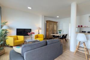 a living room with a blue couch and yellow chairs at Casa en la montaña in Montana la Data