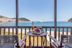 斯科派洛斯Nikolaos studios apartments的一张桌子,上面放着一瓶葡萄酒和一些酒杯