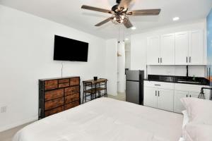 1 dormitorio blanco con ventilador de techo y cocina en Blue Mist Motel - Room #7, en Daytona Beach
