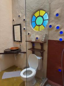 ein Badezimmer mit Toilette und Buntglasfenster in der Unterkunft Ecocentro Brasil - Bangalô 4 in São Pedro + 21 Fotos