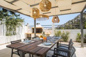 a wooden table and chairs on a patio at Villa Melia in Koskinou