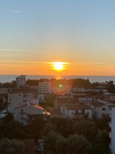 a sunset over a city with buildings and the ocean at DakiToki apartment in Kravlja +4 photos