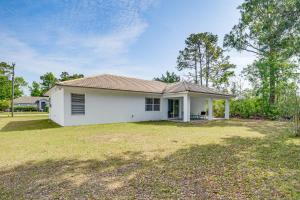 a white house with a large yard at Pet-Friendly Palm Coast Home 8 Mi to Beach! in Palm Coast