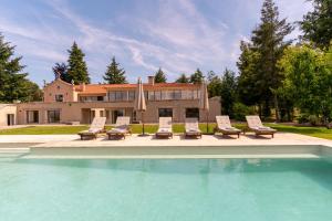 ein Swimmingpool mit Stühlen und ein Haus in der Unterkunft Casa da Raposeira Douro Valley in Armamar