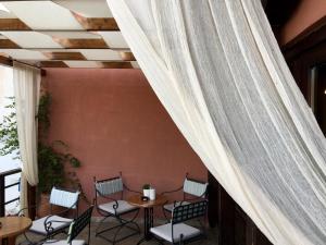 a patio with chairs and a table and a ceiling at Varosi Guesthouse in Edessa