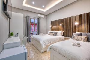 a bedroom with two beds and a couch in it at Hughesville Birgu in Birgu