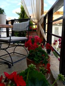 a balcony with a chair and flowers on a patio at Varosi Guesthouse in Edessa