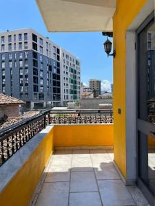a balcony with a yellow wall and some buildings at Casa Shpresë - The Traditional Suite in Tirana +38 photos