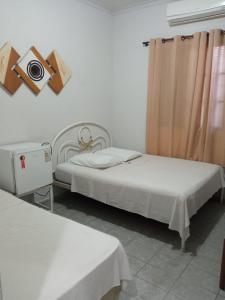 a bedroom with two beds and a camera on the wall at Hotel JF in Pirassununga