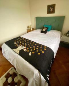 a bed with a black and yellow blanket on it at Lindo Departamento Centro in Osorno