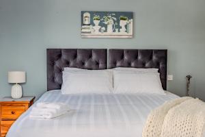 una camera da letto con un letto grande con testiera nera di Spacious Apartment Killorglin Town Centre a Killorglin
