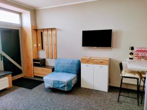 a room with a chair and a tv on a wall at Apartament Na Reymonta in Starogard Gdański