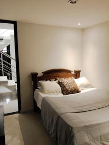 a bedroom with a bed with a wooden headboard at Hotel PREMIUM HOUSE in Floridablanca