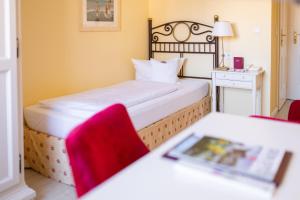 ein Hotelzimmer mit einem Bett und einem Tisch mit Spiegel in der Unterkunft Hotel Dünenburg in Westerland + 27 Fotos