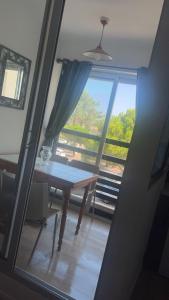 ein Raum mit einem Tisch und einem großen Fenster in der Unterkunft T2 tout équipé pour 4 personnes en bord de mer in Saint-Cyprien