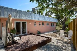 a wooden deck with two chairs and a house at Cozy 1BR Bungalow Near Beach and Pet Friendly in Sanibel