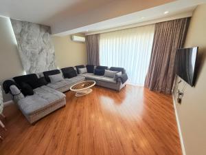 un salon avec un canapé et une télévision dans l'établissement Park Azure Royal apart, à Baku