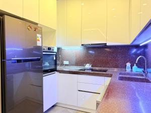 une cuisine avec des armoires blanches et un réfrigérateur en acier inoxydable dans l'établissement Park Azure Royal apart, à Baku 5 autres photos