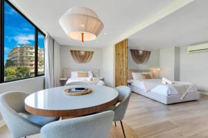 a bedroom with two beds and a table and chairs at El San Geronimo in San Juan